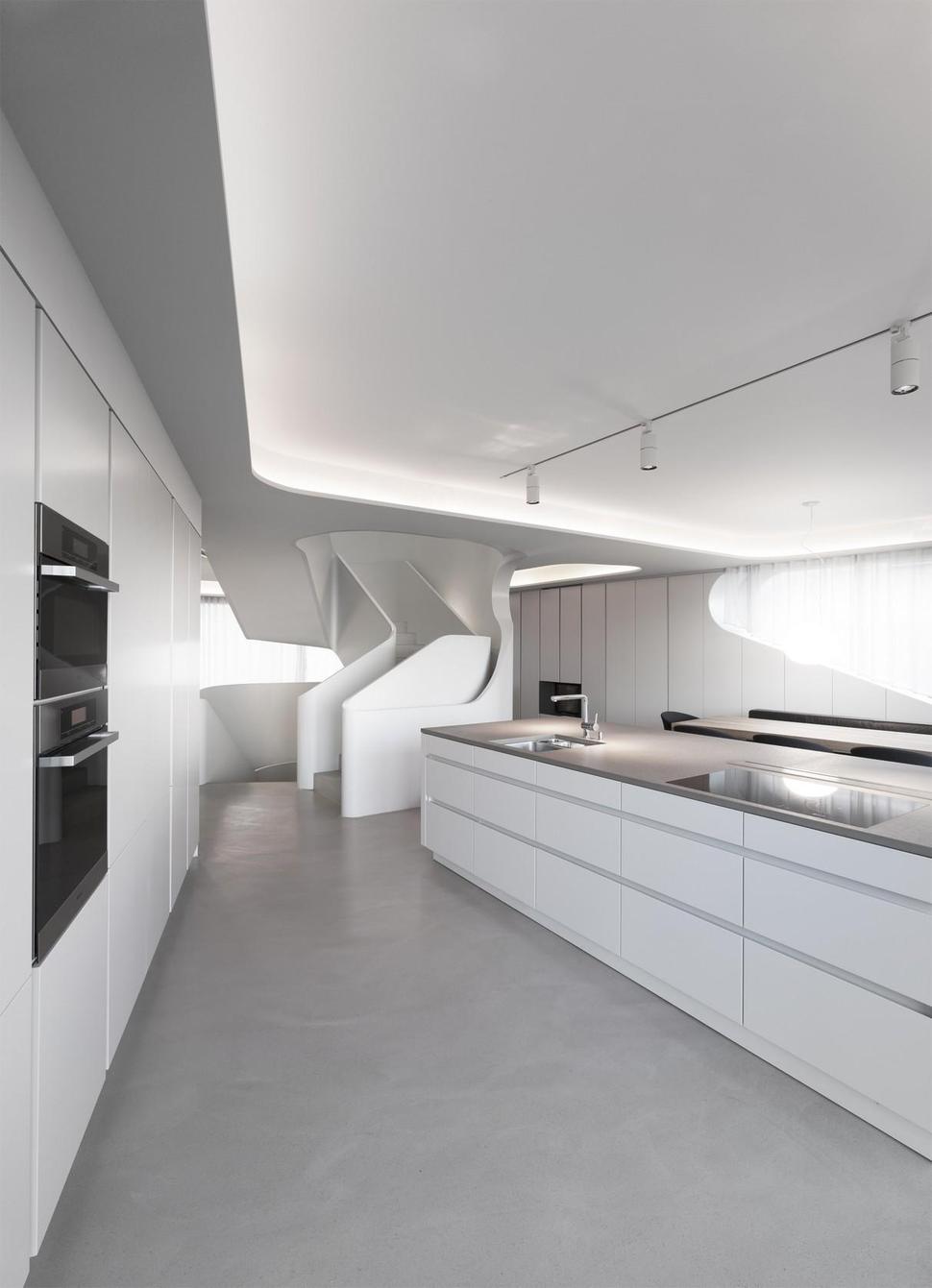 angular-modern-home-features-large-curvaceous-stairwell-inside-10-kitchen.jpg