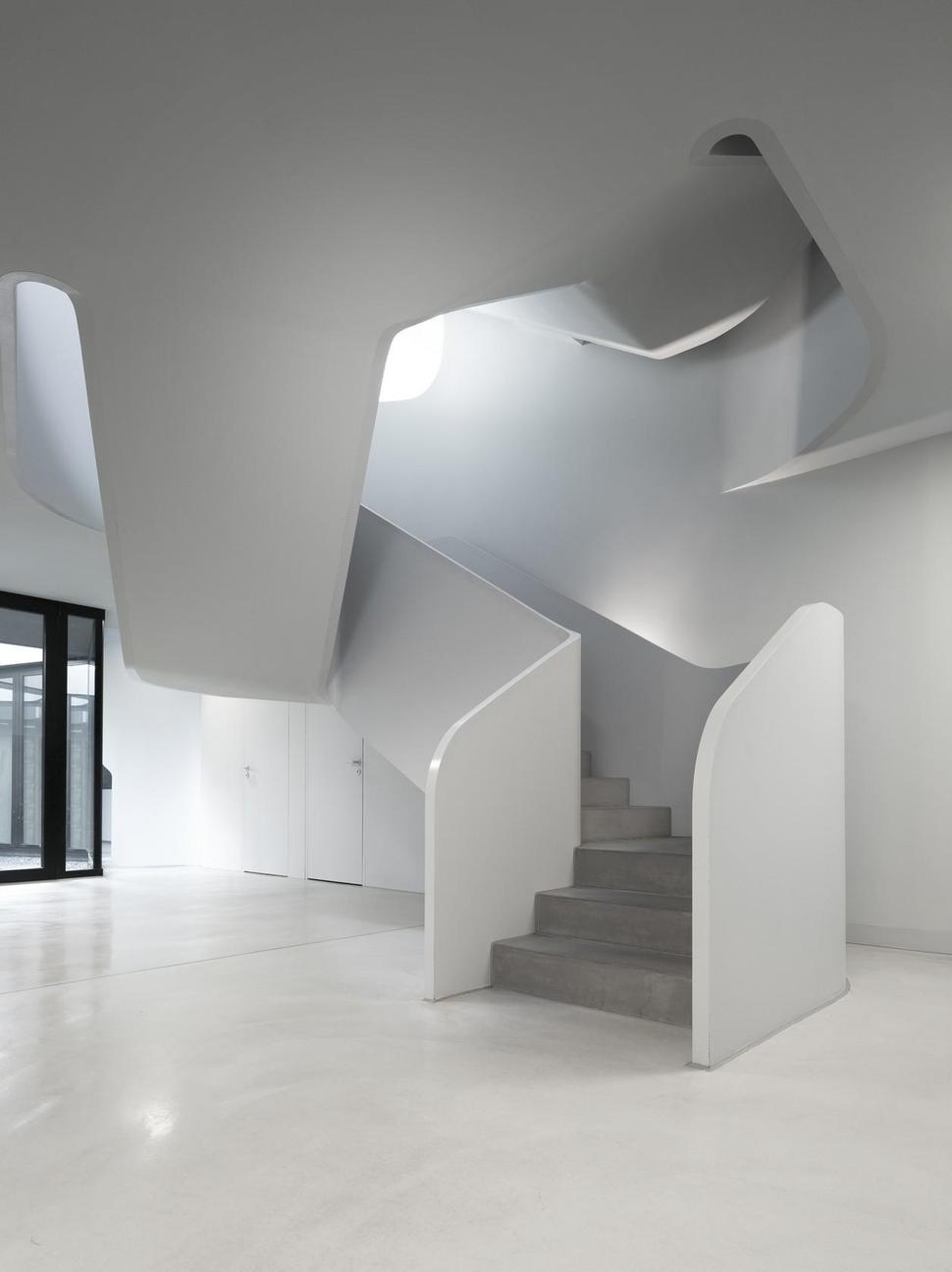 angular-modern-home-features-large-curvaceous-stairwell-inside-6-foyer.jpg