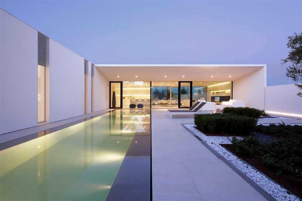 serene-white-house-with-walled-outdoor-space-7-evening-pool-far.jpg