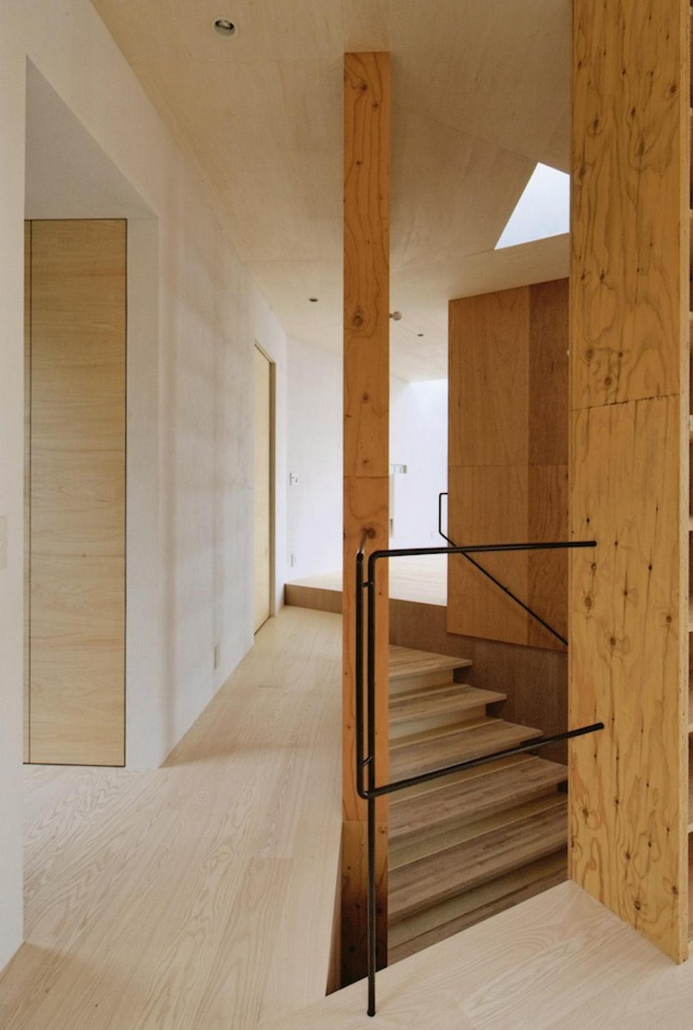 steep-slope-house-with-bookshelf-lined-interior-9-stairs-passageway.jpg