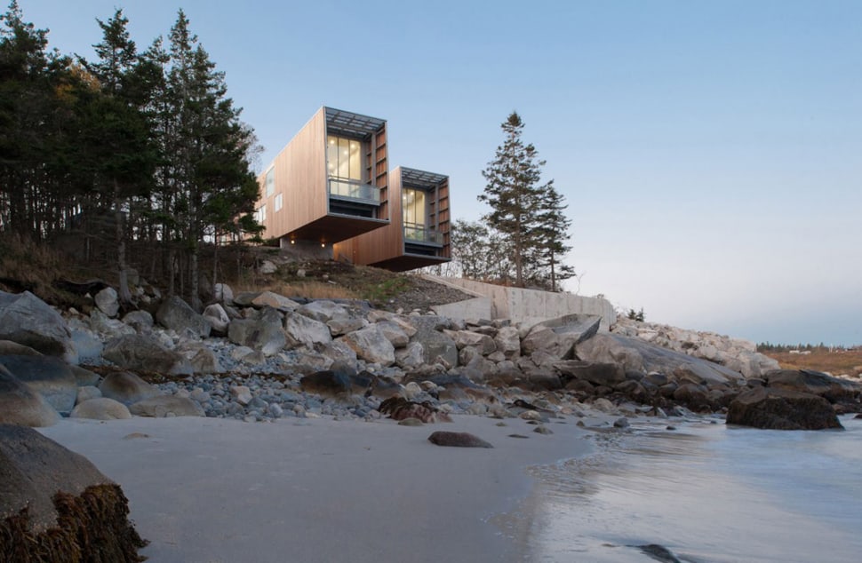 Boat inspired wood house hanging over the ocean