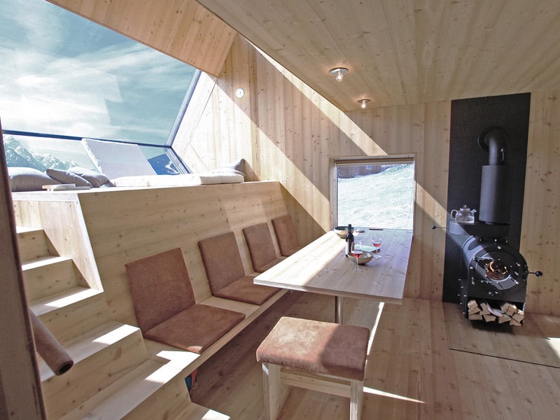 compact irregularly shaped austrian mountain house on stilts 10 table windows