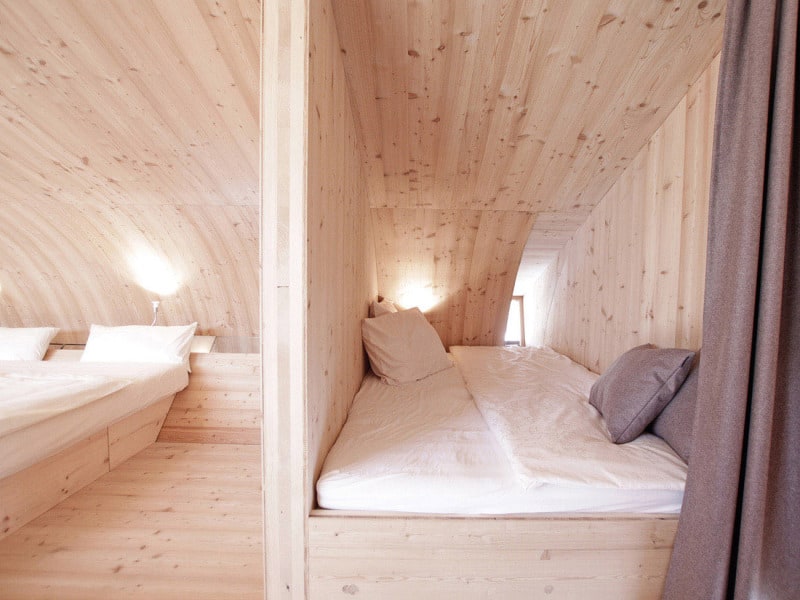 compact irregularly shaped austrian mountain house on stilts 17 small bed