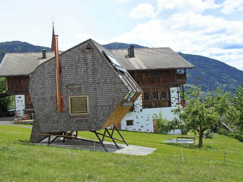 compact irregularly shaped austrian mountain house on stilts 3 side chimney