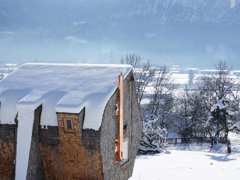 compact irregularly shaped austrian mountain house on stilts 6 above winter
