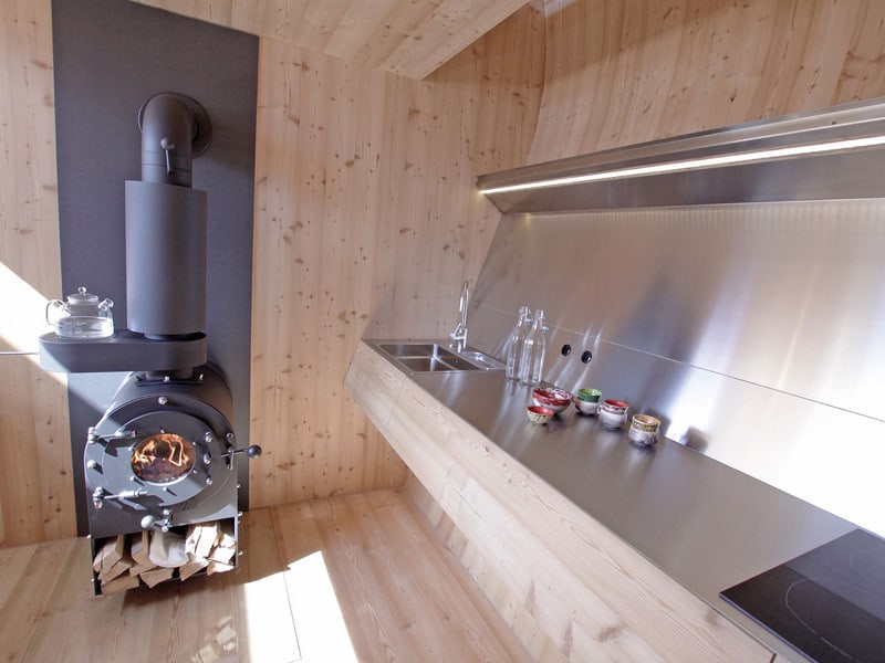 compact irregularly shaped austrian mountain house on stilts 8 kitchen
