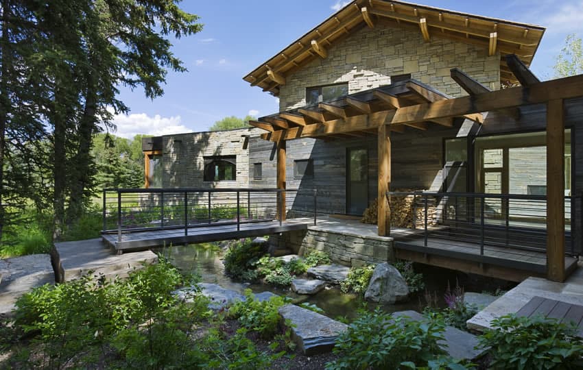 contemporary stone farmhouse with aged wood siding segments 6 bridges