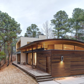 Contemporary Forest House with Curved Metal Roof