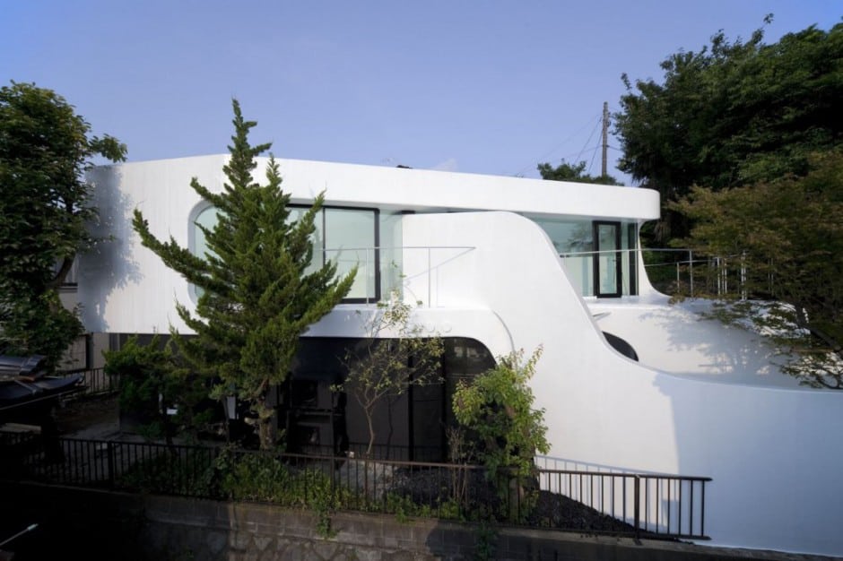 futuristic curved wall house integrates nature and architecture 1