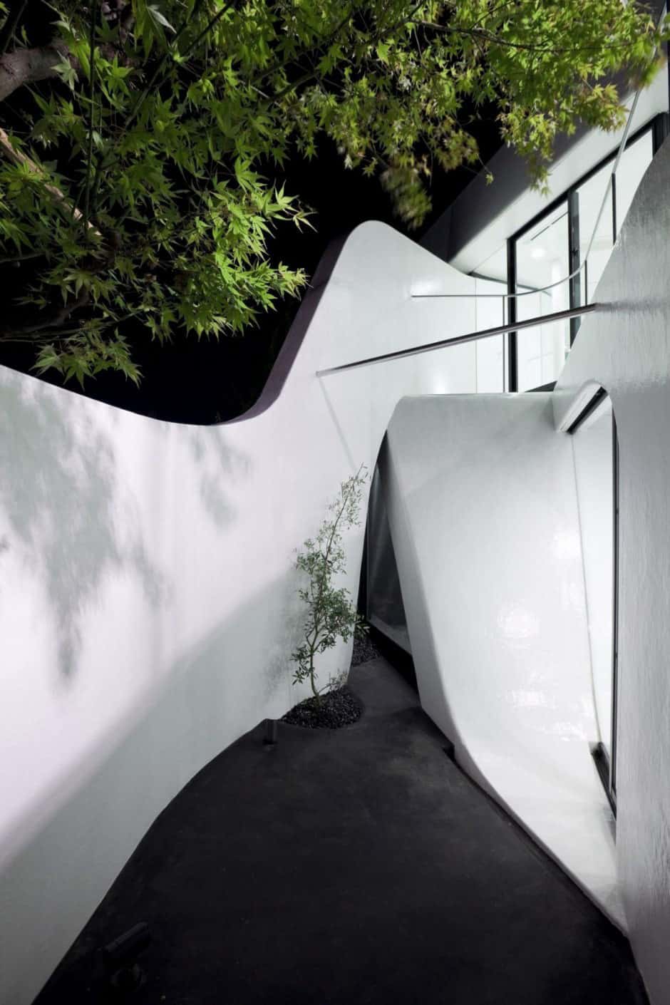 futuristic curved wall house integrates nature and architecture 11