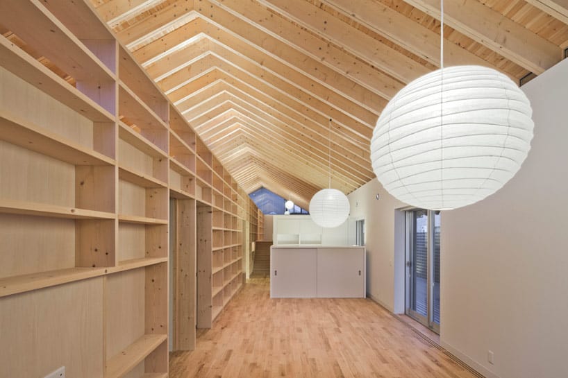 house-with-exposed-timber-rafters-bookshelf-columns-4-downstairs-night.jpg