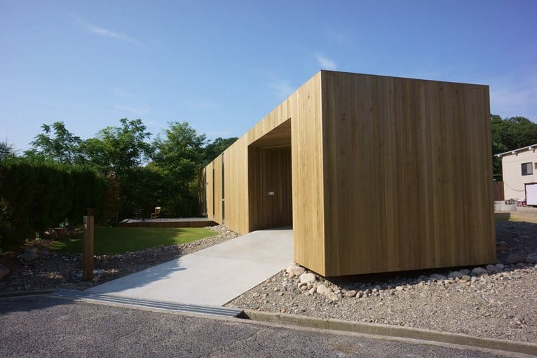 various wood finishes populate uniquely natural japanese home driveway angle