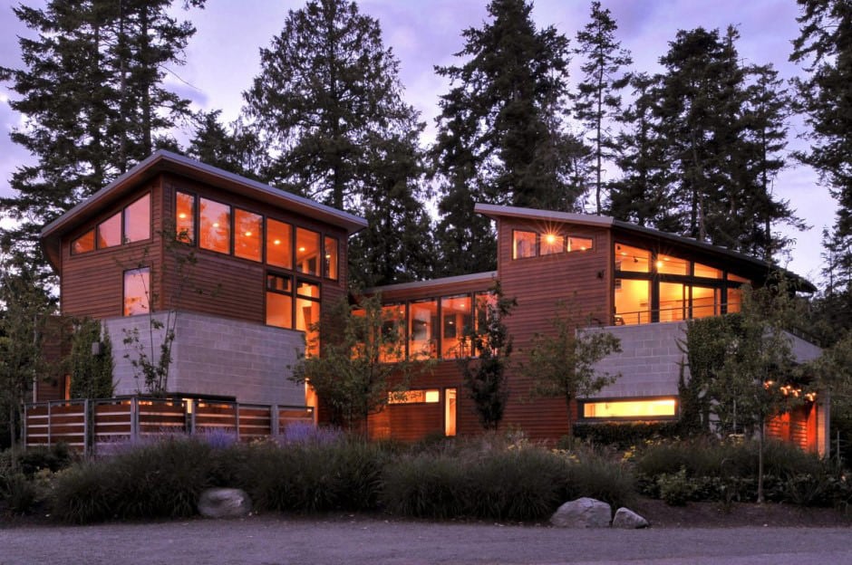 wood house with curved glass walls overlooking sunset bay 1